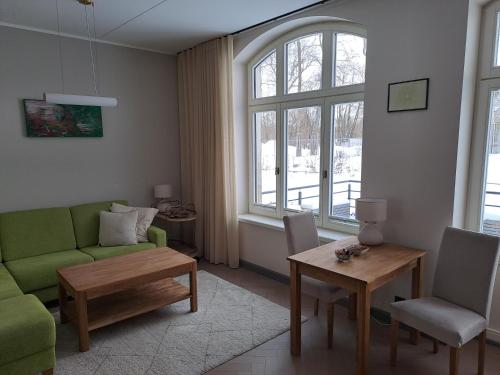 a living room with a green couch and a table at Signe Apartment in Tartu