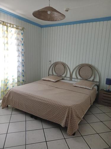 a bedroom with a large bed in a room at Appart'hotel La croisière in Gourbeyre