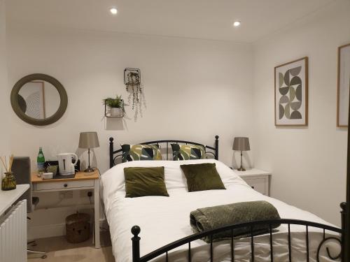um quarto com uma cama e uma mesa com um espelho em Fly By em Duxford