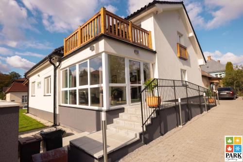 a house with a balcony on top of it at Apartmány PARK in Turčianske Teplice