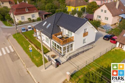 a large white house with a porch on a street at Apartmány PARK in Turčianske Teplice