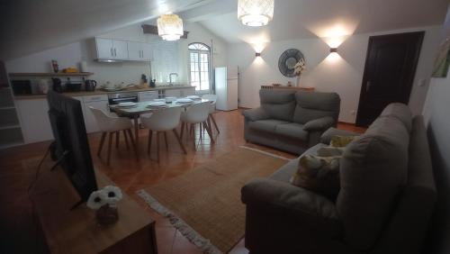 a living room with a couch and a table and a kitchen at O Miradouro in Angra do Heroísmo