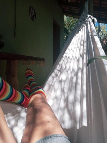 a person laying on a hammock with socks on at Chalé Nova Aurora in Alto Paraíso de Goiás