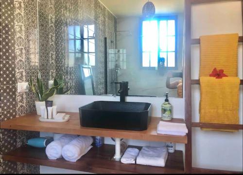 uma casa de banho com um lavatório preto e um espelho em Stylish room by the beach em Las Galeras