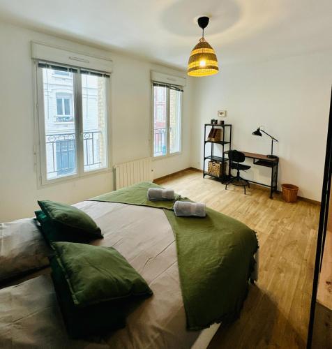 a bedroom with a large bed in a room with windows at Appartement F3 - Palais de Justice in Le Havre