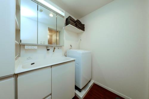 uma casa de banho branca com um lavatório e um frigorífico em Kiyosumi SOHO4B, 5th floor, 6th floor - Vacation STAY 20597v em Tóquio