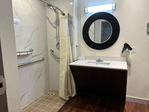 a bathroom with a sink and a shower with a mirror at Expo Inn and Suites Belton Temple South I-35 in Belton