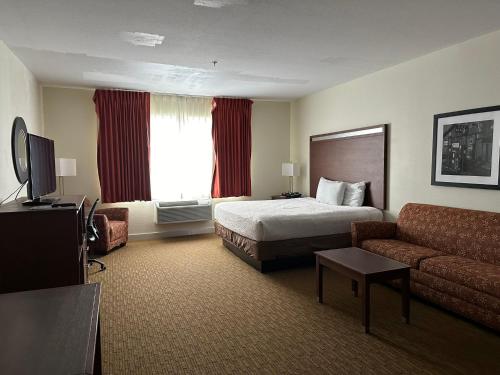 Habitación de hotel con cama y sofá en Expo Inn and Suites Belton Temple South I-35, en Belton