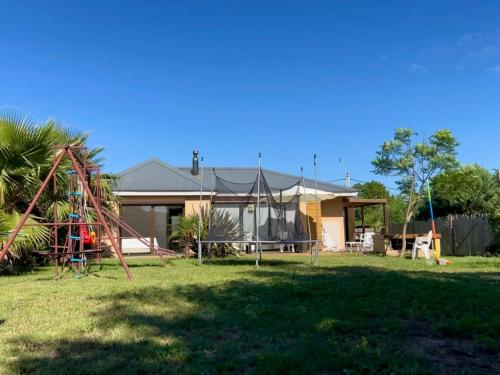 a house with a playground in the yard at Casa ideal para vacaciones en familia in Punta del Este