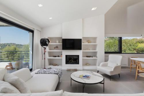 a living room with white furniture and a fireplace at Gaia - A Secret Luxury Hideaway in Achílleion