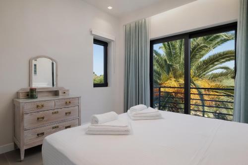 a bedroom with a bed and a mirror and a window at Gaia - A Secret Luxury Hideaway in Achílleion