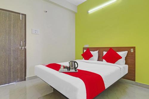 a bedroom with a large bed with red pillows at Hotel Elite Stay Near Habsiguda Metro Station in Hyderabad