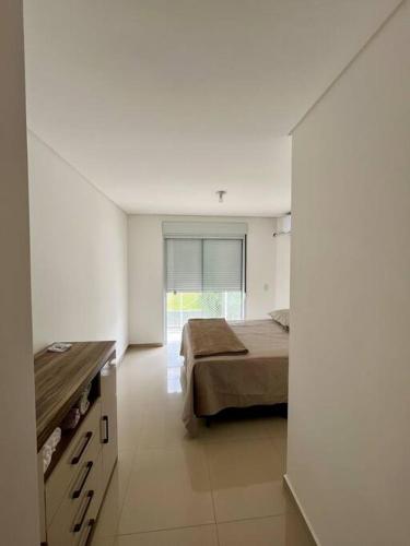1 dormitorio con cama y ventana grande en Casa prox. a praia do Campeche en Florianópolis