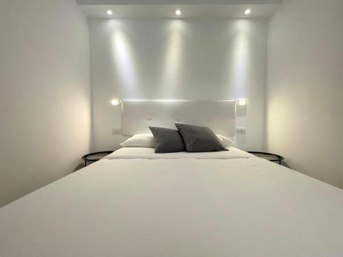 una camera da letto con un letto bianco e luci di MarketHome Lagos de Mareverde ad Adeje