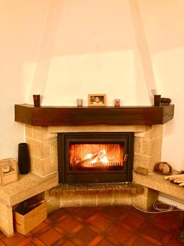 a fireplace in a living room with a fire at Cheerful villa with fireplace, bath-tub and garden in Noville