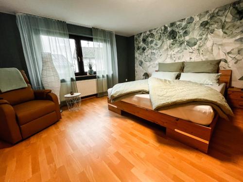 a bedroom with a bed and a chair at Ferienwohnung im Mittelrheintal, Traumschleife & Rheinsteig Wanderwege! in Damscheid