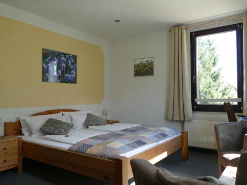 a bedroom with a bed and a window at „Frische Quelle“ Jonsdorf in Kurort Jonsdorf