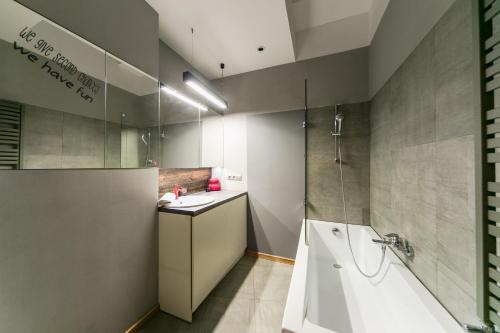 a bathroom with a tub and a sink and a shower at Warsaw Concierge Metro Loft in Warsaw