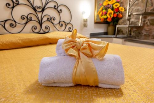 a pile of towels with a bow on a bed at The Vernazza Main Plaza - Rooms & Apartment in Vernazza
