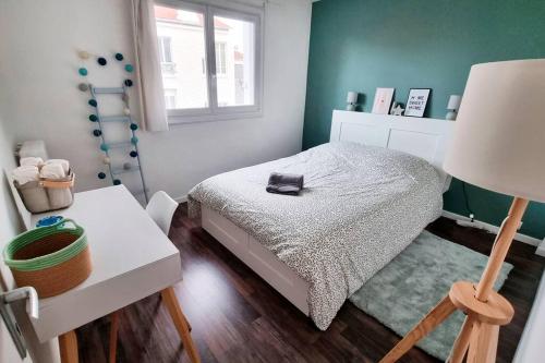 ein kleines Schlafzimmer mit einem Bett und einer Lampe in der Unterkunft Cocon familial proche de Paris in Issy-les-Moulineaux