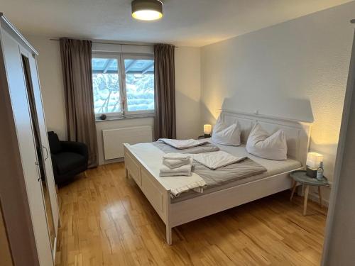 um quarto com uma cama branca e uma janela em Weideblick, traumhaft wohnen im Schwarzwald em St. Georgen