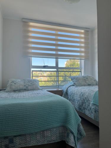 sypialnia z 2 łóżkami i oknem z żaluzjami w obiekcie apartamento nuevo comodo 4 camas w mieście Viña del Mar