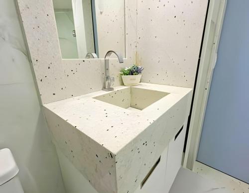 a bathroom with a concrete sink and a mirror at Flat Radisson Recife in Recife