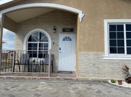 a house with a white door and a patio at The Cameron @ Phoenix Park in Portmore