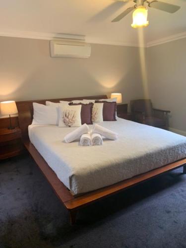 a bedroom with a bed with two slippers on it at Heritage Guesthouse in South West Rocks