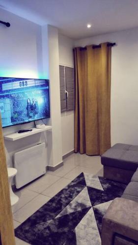 sala de estar con TV de pantalla grande en una habitación en Beau T2 à Stains en Stains