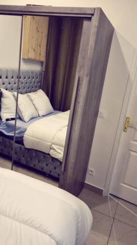 reflejo de una cama en un espejo en una habitación en Beau T2 à Stains en Stains