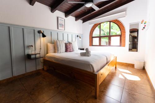 a bedroom with a bed with a stuffed animal on it at Maya Papaya in Antigua Guatemala