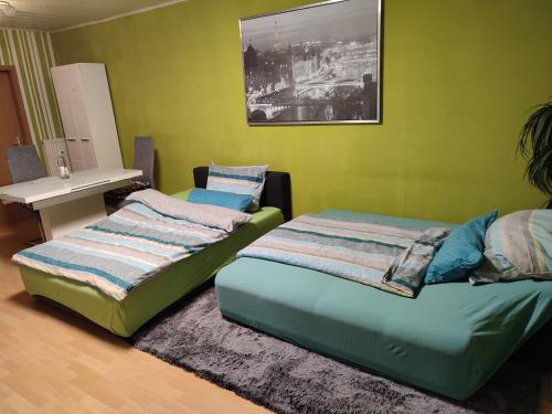 2 camas en una habitación con paredes verdes en Komfortable Ferienwohnung in Flörsheim-Weilbach, en Flörsheim