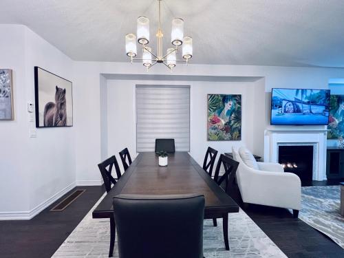 a dining room with a table and chairs and a fireplace at Brand New! Modern Luxury Retreat! in Barrie