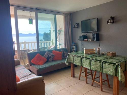 a living room with a table and a couch and a television at Condominio Bahia Pelicanos - Horcon in Puchuncaví