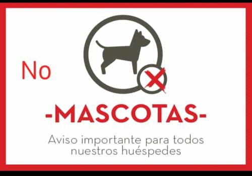 a sign with a picture of a dog and a no measles sign at Descanso al Paso Chuy in Chuy