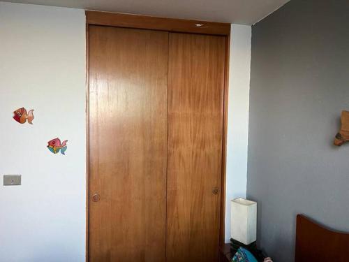 a wooden door in the corner of a room at Condominio Bahia Pelicanos - Horcon in Puchuncaví