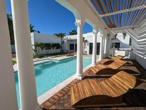 ein Haus mit einem Pool und einer Veranda in der Unterkunft CASA ROMA Hotel Boutique in El Tamarindo