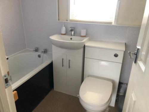 een badkamer met een wit toilet en een wastafel bij 2 bed dog friendly chalet on sunbeach Scratby in Great Yarmouth