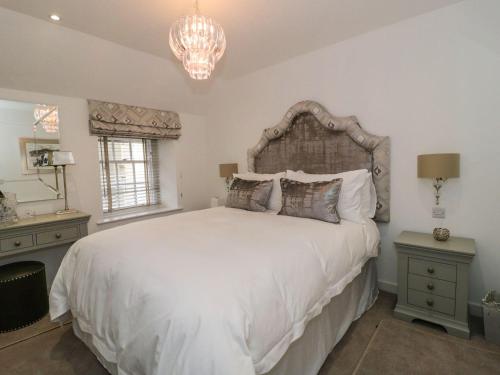 a bedroom with a large white bed and a chandelier at 9 Chapel Street in Conwy