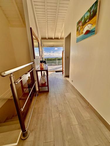 a hallway with a staircase with a view of the ocean at La Barque 1 in Courcelles Sucrerie