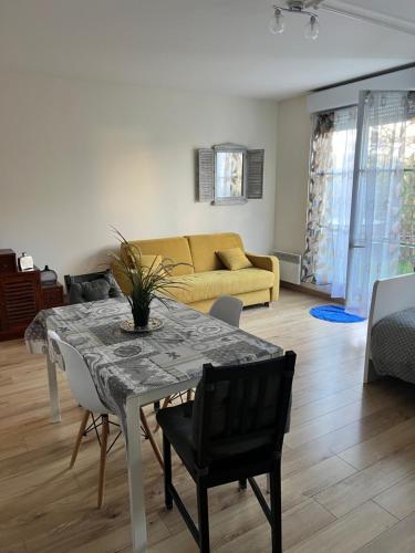 a living room with a table and a yellow couch at Appartement Disneyland Paris Val d'Europe La vallée Village parking 500m gare Val d'Europe in Montévrain