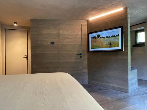 a bedroom with a flat screen tv on a wall at LA RÊVERIE DE THUMEL - CHAMBRES in Rhêmes-Notre-Dame