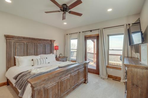 a bedroom with a large bed with a ceiling fan at Spacious Harrison Vacation Rental with Deck and Views! in Harrison