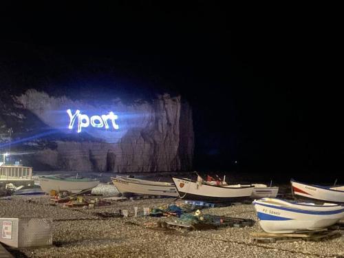 a group of boats sitting on the beach at night at Yport, maison de pêcheur avec jolie terrasse. in Yport
