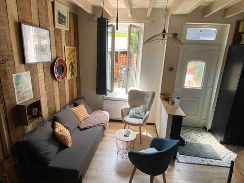 a living room with a couch and a chair at Yport, maison de pêcheur avec jolie terrasse. in Yport