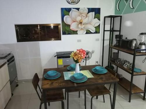 a kitchen with a wooden table with a vase of flowers on it at Cabañas Mantas in Jacó