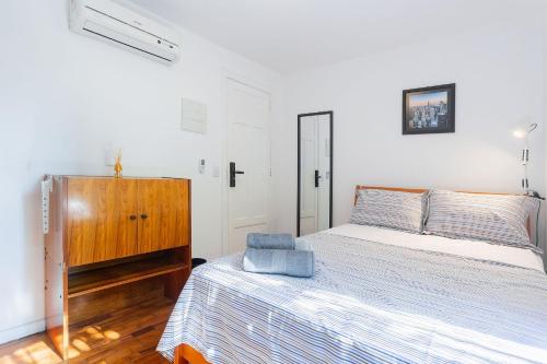 a bedroom with two beds and a wooden dresser at Studios do Vale 1 in Sao Paulo