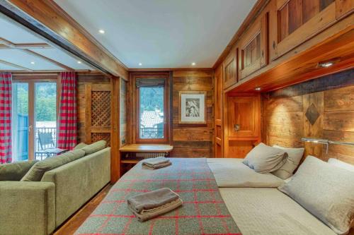 une chambre avec un grand lit et un canapé dans l'établissement Chamonix centre, « Lucille »,balcon, vue imprenable et parking, à Chamonix-Mont-Blanc