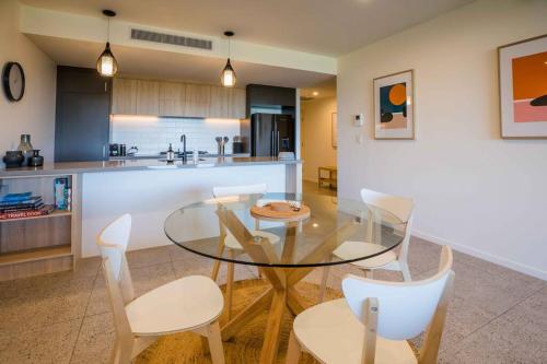 a dining room and kitchen with a glass table and chairs at The Beach Oasis ~ Dune in Kingscliff